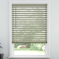 a window with blinds that are closed in front of a white wall and potted plant