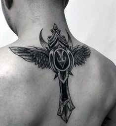 the back of a man's neck with an ornate cross and wings on it