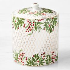 a ceramic container with holly and berries on it