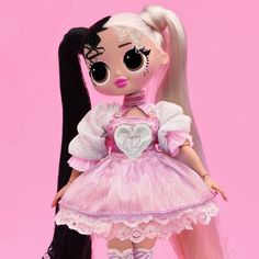 a doll with long hair wearing a pink dress and white shoes is standing in front of a pink background