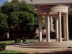 a large white building with columns in front of it and trees on the other side