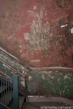 an old wall with peeling paint on it and some stairs leading up to the top