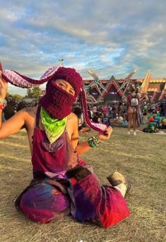 two people sitting on the ground with their faces covered in crochet