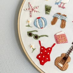 a close up of a embroidery on a white surface with various items in the hoop