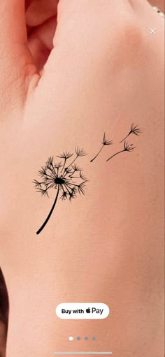 a small dandelion tattoo on the back of a woman's left arm