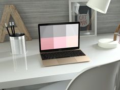 an open laptop computer sitting on top of a white desk next to a lamp and pictures