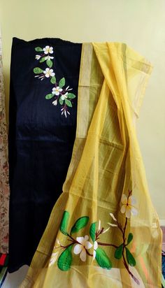 two pieces of yellow and black cloth with flowers on them are sitting next to each other