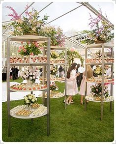 two people standing in front of an assortment of desserts on display at a wedding