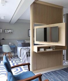 a living room filled with furniture and a flat screen tv on top of a wooden shelf