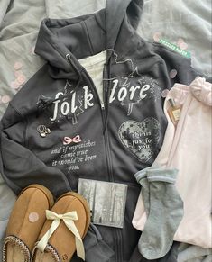 a couple of pairs of shoes sitting on top of a bed next to some clothing