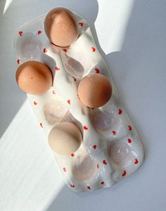 an egg tray with six eggs in it on a white surface, top down view