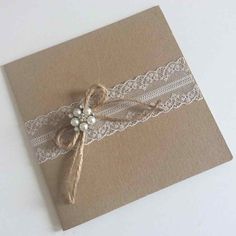 a brown card with lace and pearls on it, sitting on top of a table