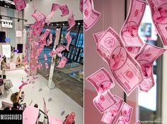 pink money is falling from the ceiling and people are looking at them in the store