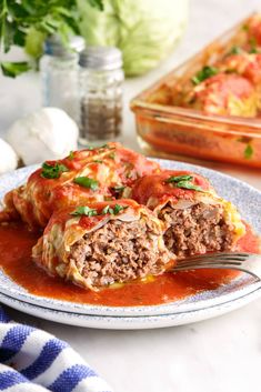 an enchilada on a plate with a fork in it and another dish next to it