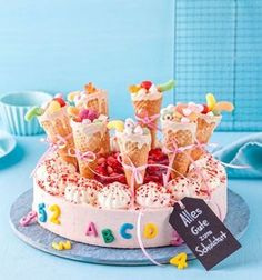 a birthday cake decorated with lots of candy and sprinkles on a blue table