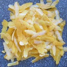 some yellow food is laying on a blue counter top and it looks like they have been cut into small pieces