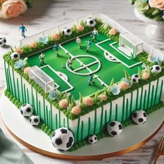 a soccer field cake is shown on a plate with flowers and greenery around it