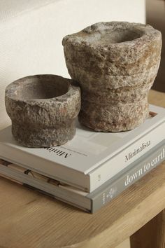 two stone pots sitting on top of a book