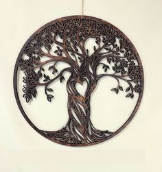 a metal wall hanging with a tree in the center and leaves on it's sides