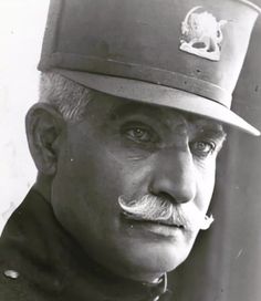 an old black and white photo of a man wearing a hat with a mustache on it