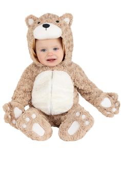 a baby in a teddy bear costume sitting on the ground