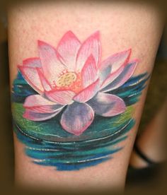 a water lily tattoo on the side of a woman's leg with blue and pink colors