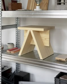 a wooden stool sitting on top of a shelf next to other shelves in a room