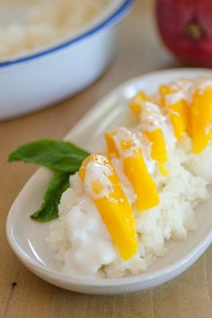 a plate with rice and orange slices on it next to an apple in the background