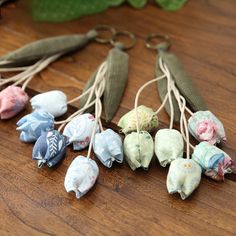 several small pieces of fabric tied together on a wooden table next to some green leaves