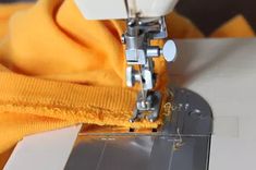 the sewing machine is working on the yellow sweater