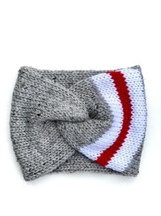 a knitted bow tie on top of a gray and white hat with red stripes