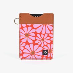 an orange and pink flowered wallet with a keychain hanging from the front