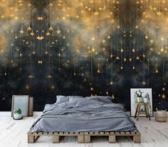 a bed sitting under a wall covered in stars