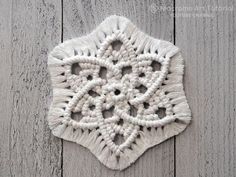 a white crocheted doily hanging on a wooden wall