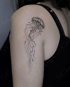 a woman's shoulder with a tattoo of a jellyfish