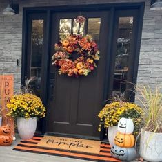 front door decorated for halloween with pumpkins and flowers