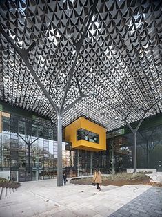 a person walking in front of a building with an intricate ceiling design on the roof