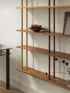 a wooden shelf with some books on it and a vase filled with flowers next to it