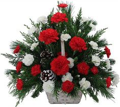 a christmas basket filled with red and white carnations, pine cones and evergreen needles