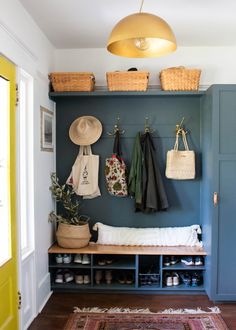 the entryway is decorated with baskets and coat racks, while hanging coats are also on the wall