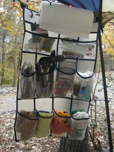 an umbrella is hanging on the side of a tree with many items in it,