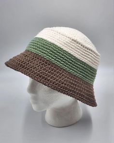 a white mannequin head wearing a multicolored crocheted bucket hat