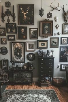 a living room filled with lots of framed pictures and deer heads on the wall above a dresser