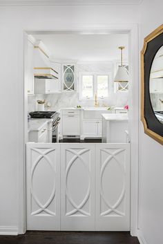 an open door leading to a white kitchen