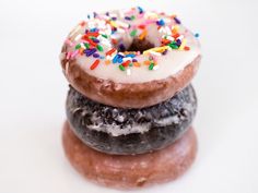 three donuts stacked on top of each other with sprinkles