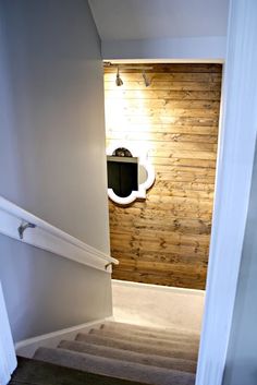 an open door leading to a bathroom with wooden walls