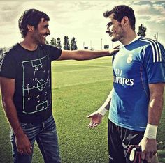 two men standing on top of a soccer field holding onto each other's hands