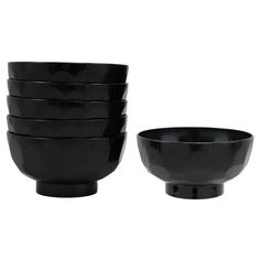 four black bowls stacked on top of each other in front of a white background,