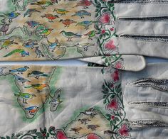 two pairs of white gloves with birds on them, one is decorated with flowers and leaves