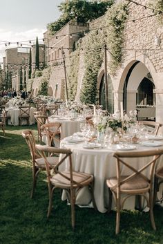 an outdoor dining area with tables and chairs set up in front of a stone building